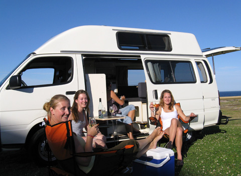 Four lovely girls sitting outside the Campervan Hire Australia Deals van