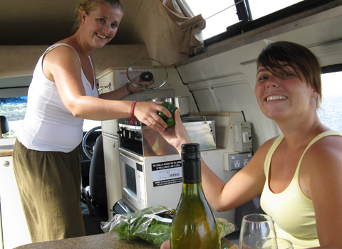 Budget Campervan Hire with two girls cooking in the kitchen