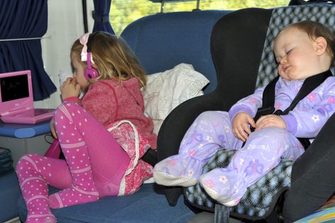 Two young children with proper child seat belts in a Campervan
