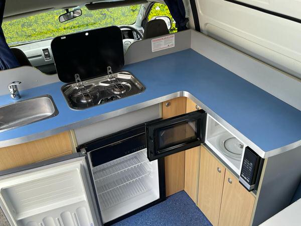 Kitchen with sink, 80L fridge and Microwave in this Toyota Automatic Campervan