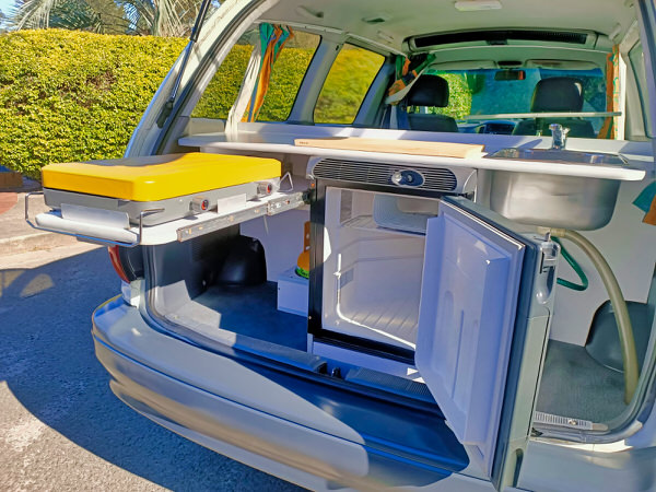 Photos showing the kitchen area with fridge, cooker and sink in a Toyota automatic 2 person campervan
