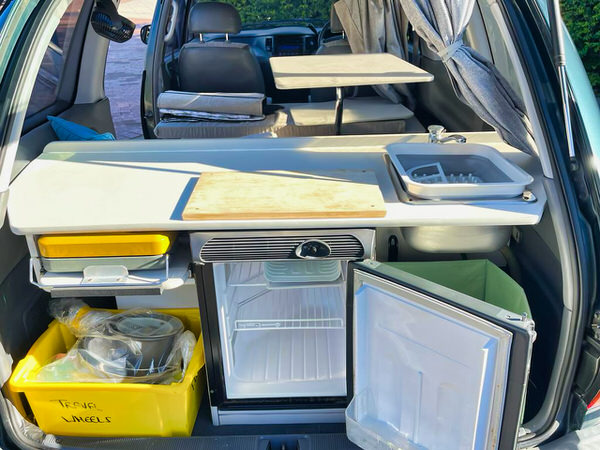 used toyota tarago campervans for sale - Automatic Model - photo showing the rear of the campervan with the fridge door open and the cooker, sink and worktops on display