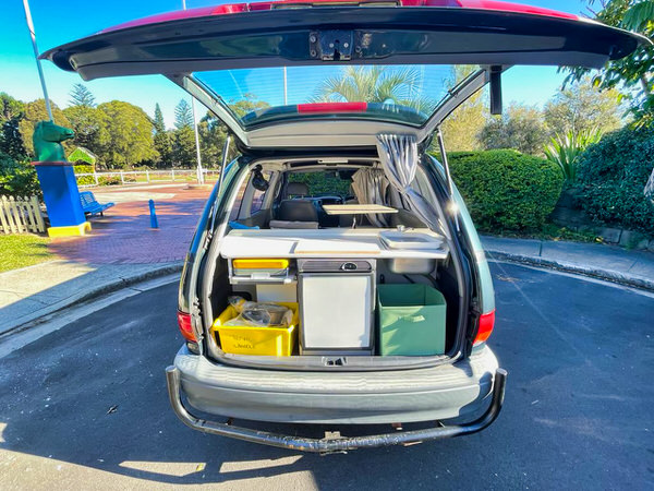 used toyota tarago campervans for sale - Automatic Model - photo showing the rear door open and the mini kitchen with fridge, cooker and sink on display