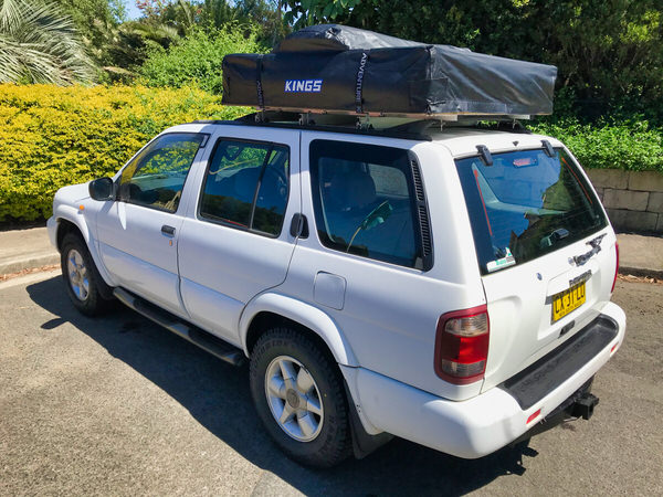 Roof Top Tent 4x4 for sale in Sydney - Model shown is a Automatic Nissan Pathfinder in white - photo showing the rear passengers side angle view with roof tent closed