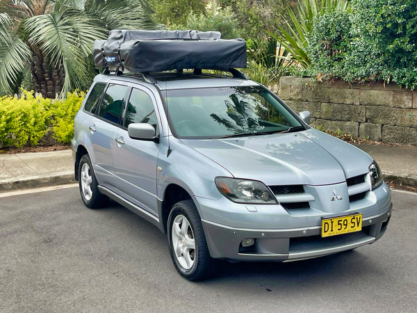 Roof Top Tent 4x4 for sale in Sydney - Model shown is a Automatic Mitsubishi Outlander with roof top tent - photo showing the front drivers side angle view with roof tent closed
