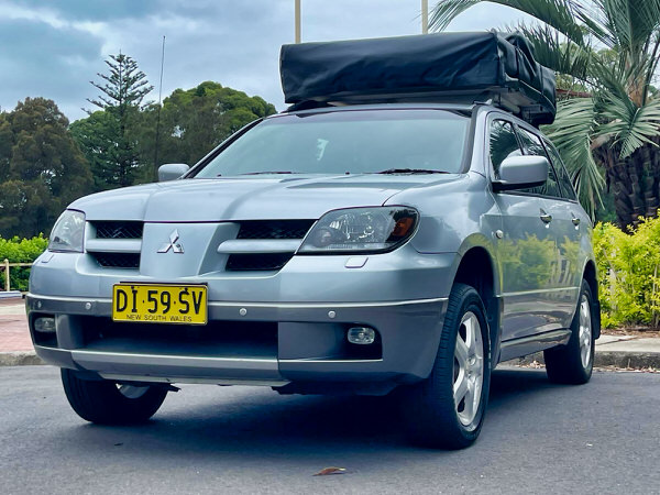Roof Top Tent 4x4 for sale in Sydney - Model shown is a Automatic Mitsubishi Outlander with roof top tent - photo showing the front passenger side angle view with roof tent closed