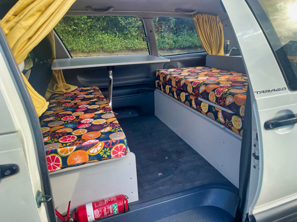 2 person campervan for sale - Toyota Tarago Automatic campervan model - photo showing the day time configuration of two benches and a moveable or removable central table in the lounge area