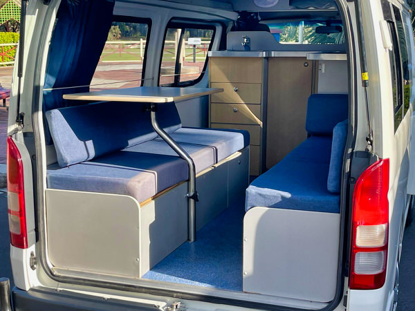 Toyota Hiace hitop campervans for sale in Sydney - Photo showing the rear lounge area with two benches and moveable table - campervan has not stickers and in very good condition
