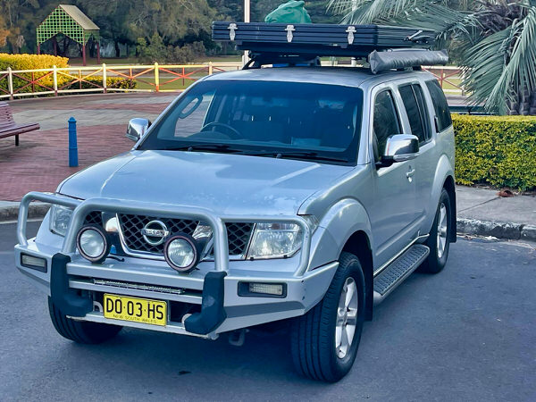 Used bush camper for sale - Model Nissan Pathfinder R51 Automatic - photo shows the front passenger side angle view with the roof top tent closed and ready to drive around Australia