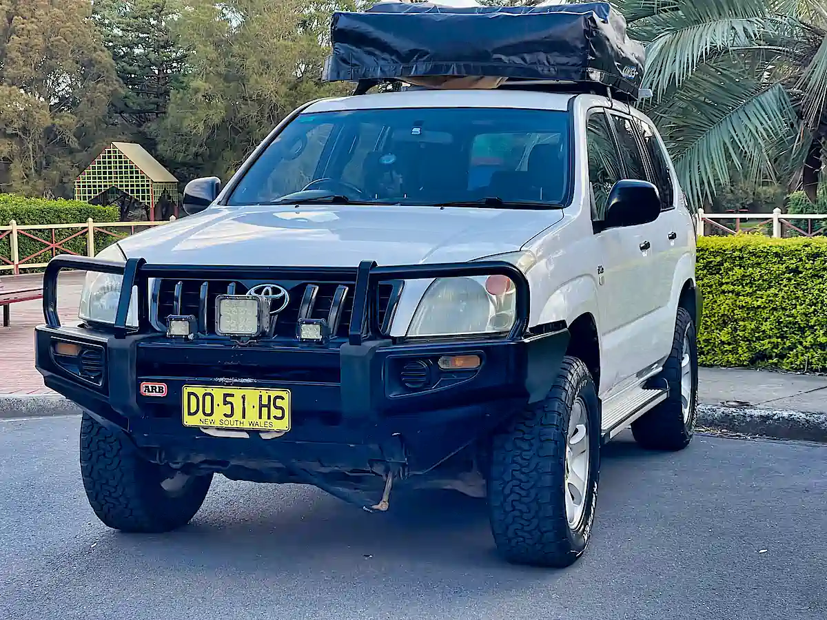 Used Toyota Prado for sale - front passenger view with roof top tent closed