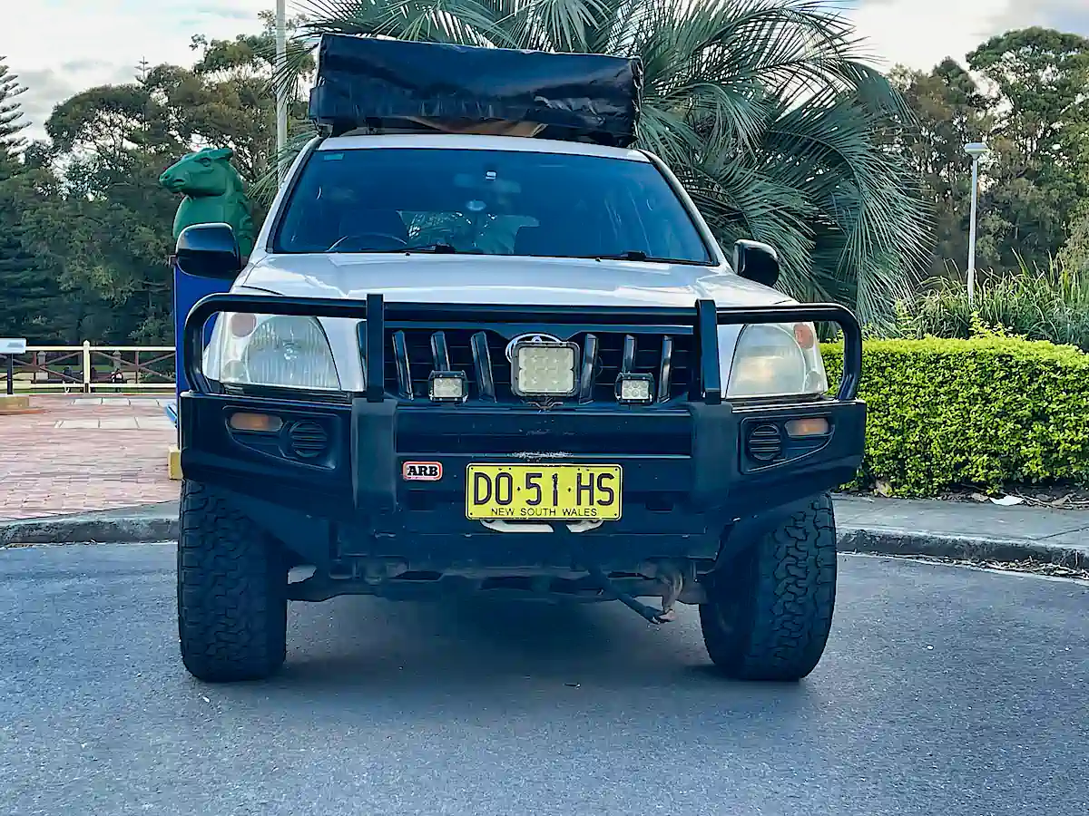 Used Toyota Prado for sale with roof top tent - front view with bull bars and spotlights