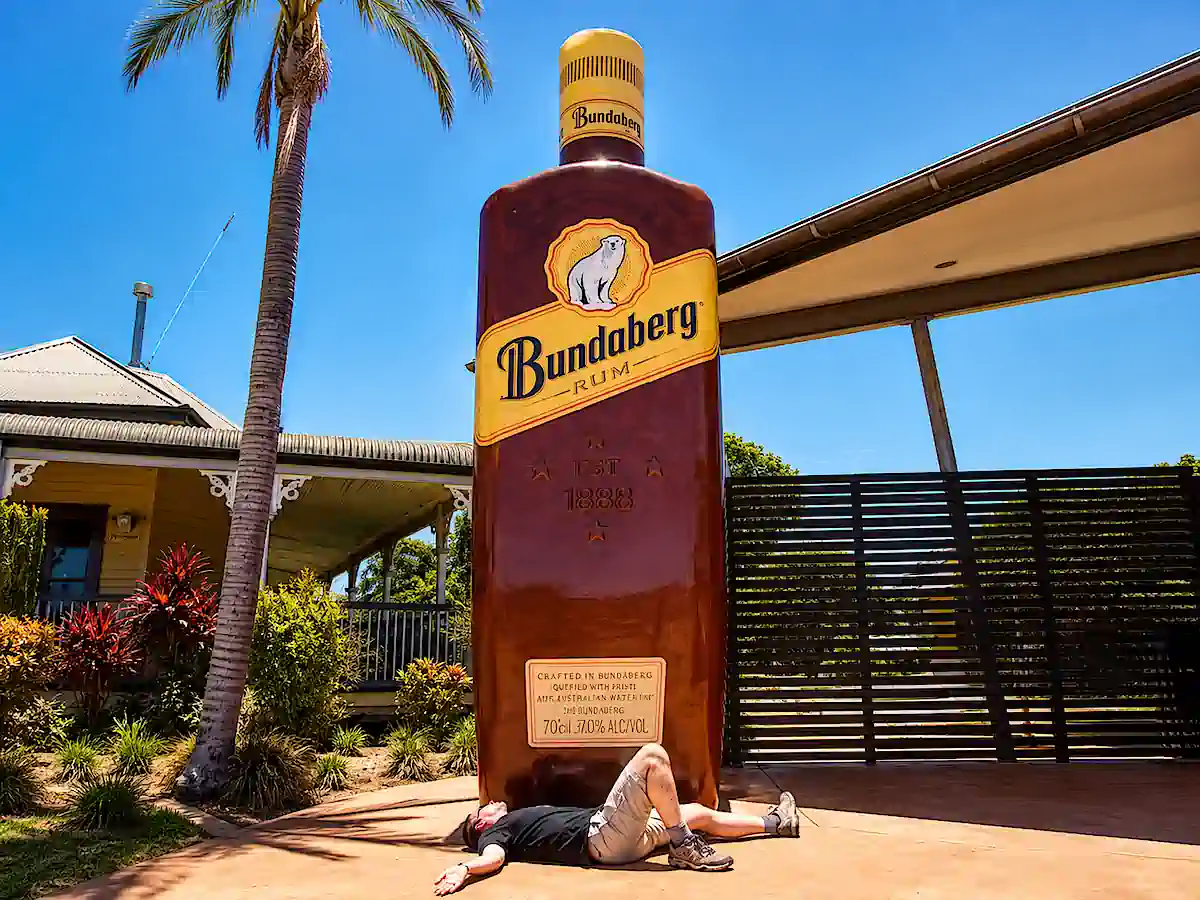 Man laying on the floor drunk next to the Big Bottle of Bundaberg Run from the The Big Things of Australia webpage