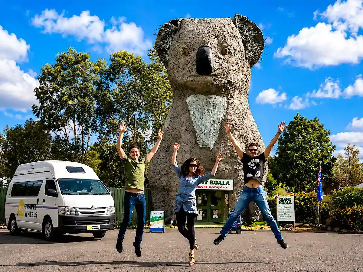 Travelwheels Campervans Customers jumping in the air at the crap Big Koala - one of the big things in Australia statues