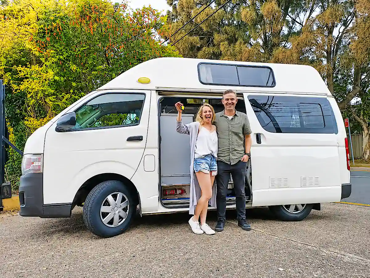 Kunden mit Schlüsseln nach dem Kauf eines gebrauchten Campervans bei Travelwheels Sydney