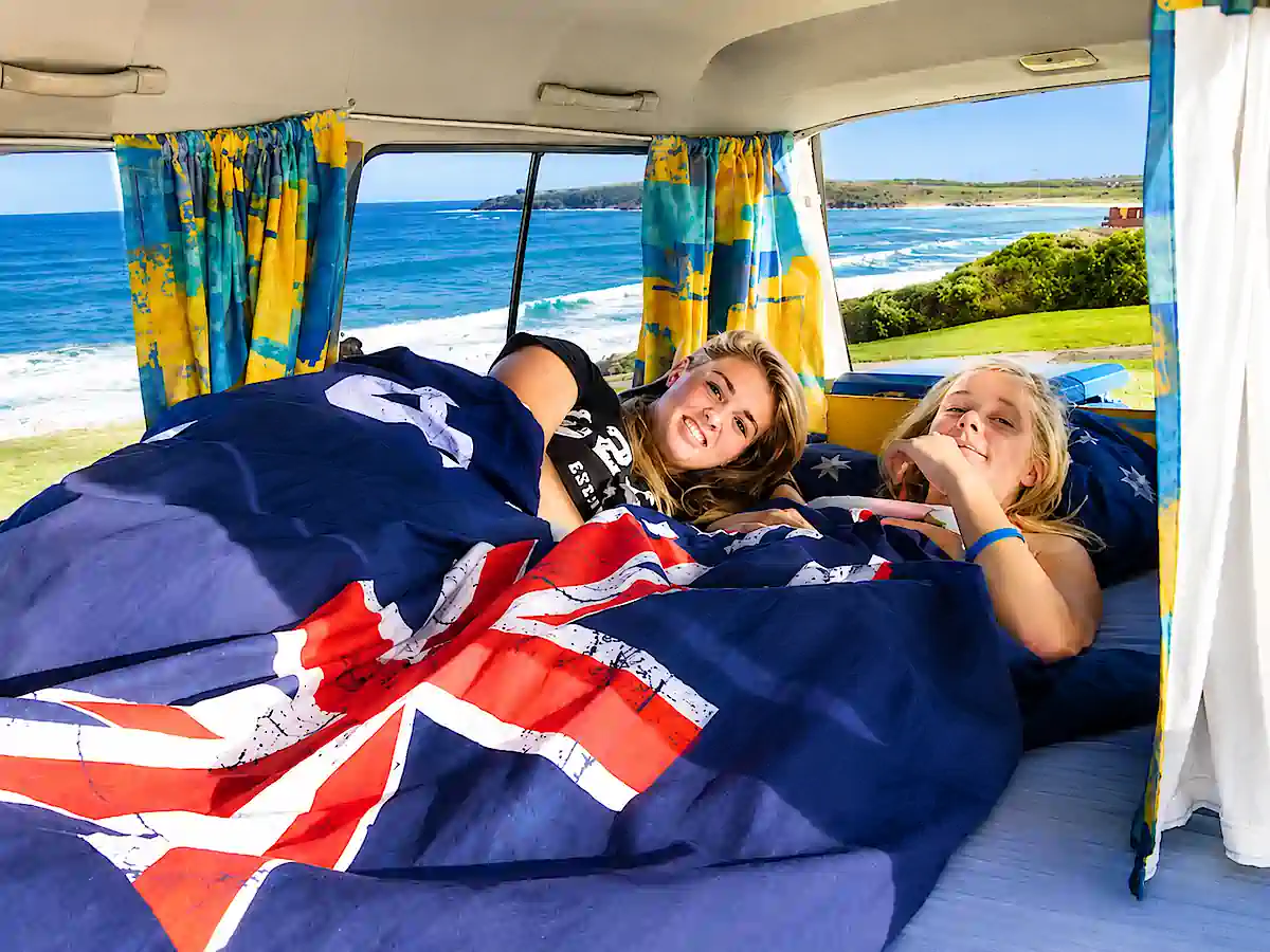 backpacker campervan for sale - double bed with two women in bed at beach