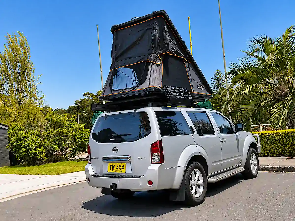 Used Bush Camper for sale - view of rear drive side with roof tent open